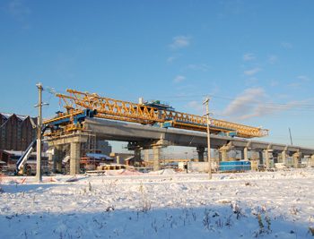 An LG (Launching Girder) machine installs pre-cast guideway segments in between support cross beams that will form the support of this centre-platform station.