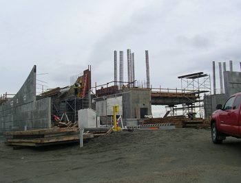 Workers disassembling a concrete form after one of the station walls is poured.