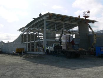Workers install roofing over the entrance and foyer of the outbound platform.