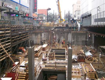 Scaffolding at the east side of the station box is used to support shotcrete work for the perimeter walls. Columns in the centre of the station are constructed to support the station escalator and stairwells.
